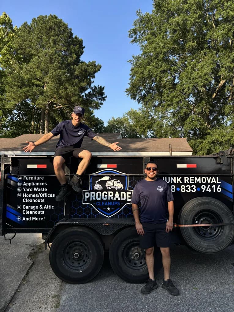 ProGrade Cleanups crew member sitting on the trailer while another stands beside it